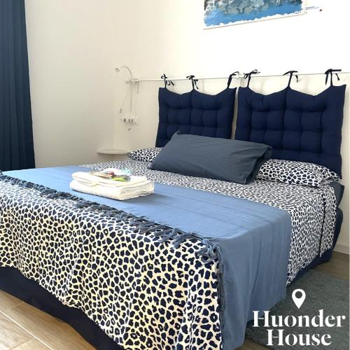 a bedroom with a bed with a blue head board at Huonder House in Lecco