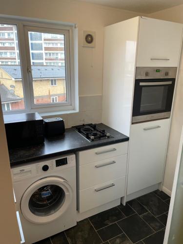 a kitchen with a stove and a washing machine at Apartment in Central London Zone 2 in London