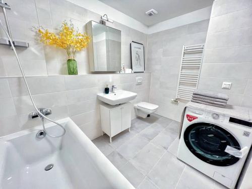 - une salle de bains blanche pourvue d'un lave-linge dans la baignoire dans l'établissement Erkel Fairy Home, à Budapest