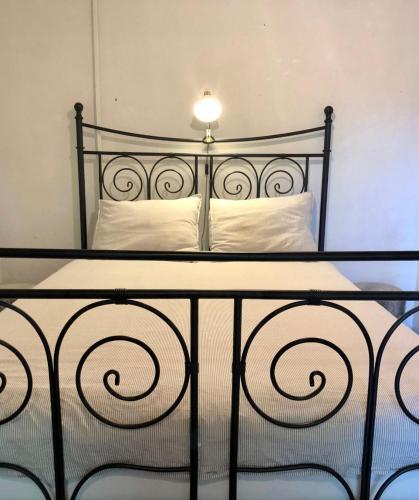 a black bed with white pillows and a lamp on it at Lovely quinta in nature with pool - Tomar in Pero Calvo