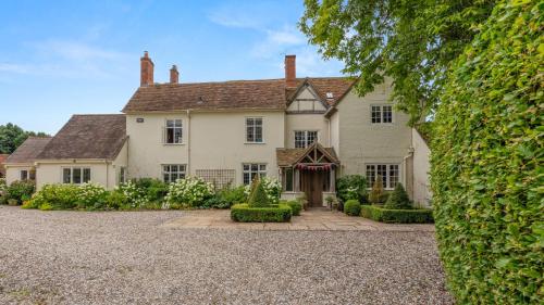 an exterior view of a large white house at Kington Grange in Claverdon