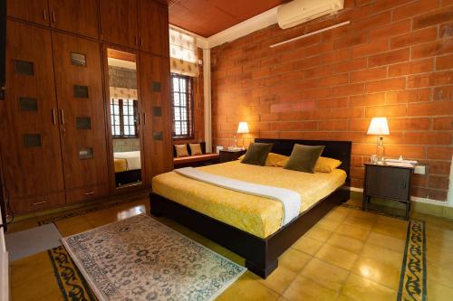 sypialnia z łóżkiem i ceglaną ścianą w obiekcie Luho 25 Whitefield w mieście Bengaluru