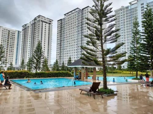 una grande piscina con persone che ci nuotano con edifici alti di Alleia's Place at SMDC Tagaytay a Tagaytay