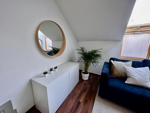 a living room with a mirror and a blue couch at Apartment Schlick - Im Zentrum von Fulpmes in Fulpmes