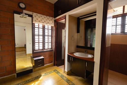 a bathroom with a sink and a mirror at Luho 25 Whitefield in Bangalore