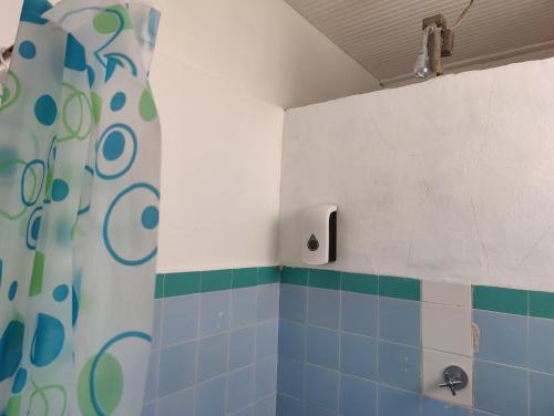 y baño con ducha y azulejos azules y verdes. en A Jewel of A Chalet en Roseau
