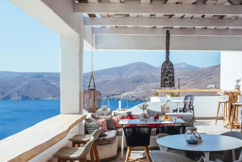 a patio with tables and chairs and a view of the ocean at Pylaia Boutique Hotel & Spa in Astypalaia