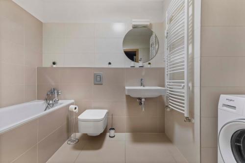ein weißes Bad mit einem Waschbecken und einem WC in der Unterkunft LAM Anthracite w AC & balcony in Bratislava