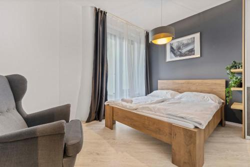 1 dormitorio con 1 cama y 1 silla en LAM Anthracite w AC & balcony en Bratislava