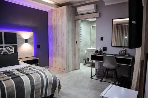 a bedroom with a bed and a desk and a sink at Cascades Guest Lodge in Nelspruit