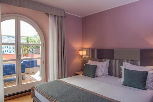 a bedroom with a bed and a large window at Grand Hotel Portovenere in Portovenere