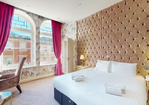 a bedroom with a large bed and a large window at The Coal Exchange Hotel in Cardiff