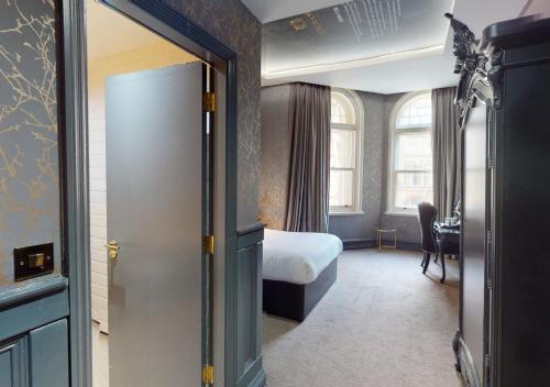 a hotel room with a bed and a room with a door at The Coal Exchange Hotel in Cardiff
