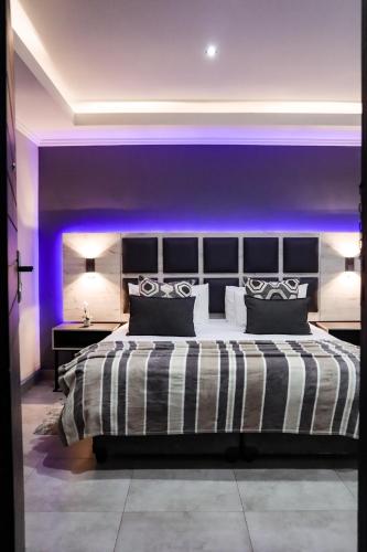 a bedroom with a large bed with purple lighting at Cascades Guest Lodge in Nelspruit
