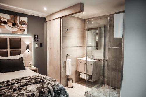 1 dormitorio con ducha, 1 cama y lavamanos en Cascades Guest Lodge en Nelspruit