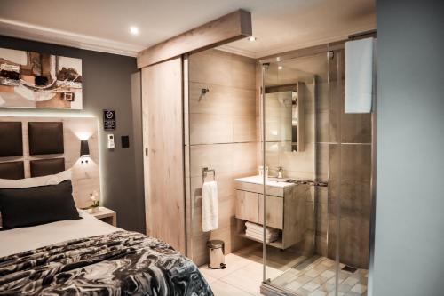 a bedroom with a shower and a bed and a sink at Cascades Guest Lodge in Nelspruit