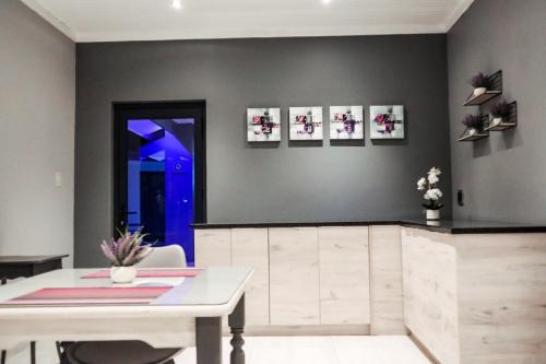 a dining room with a white table and a blue door at Cascades Guest Lodge in Nelspruit