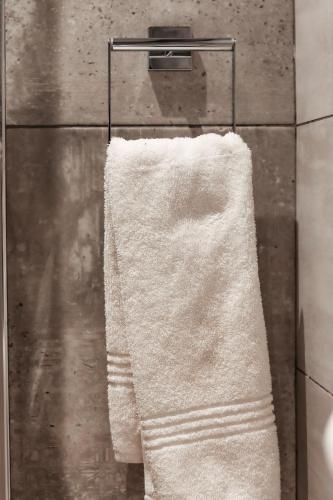 a white towel hanging on a towel rack in a bathroom at Cascades Guest Lodge in Nelspruit
