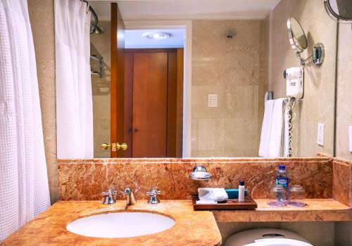 a bathroom with a sink and a large mirror at GHL Hotel Tequendama Bogotá in Bogotá