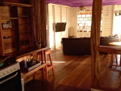 a kitchen with wooden floors and a living room at Casa Lumière in Bocas del Toro