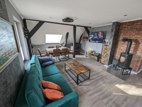 a living room with a green couch and a fireplace at Havel Suites in Havelberg