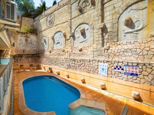 a swimming pool in front of a stone building at Apartamento en Altea con vistas al mar in Altea