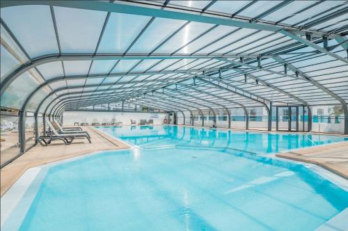 une grande piscine intérieure avec un plafond en verre dans l'établissement Chalet pour 6 personnes - piscine couverte, à Bretignolles-sur-Mer