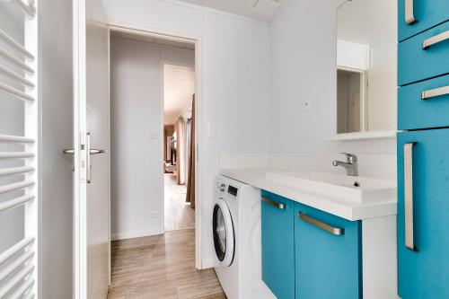 a laundry room with a sink and a washing machine at Chalet pour 6 personnes - piscine couverte in Brétignolles-sur-Mer