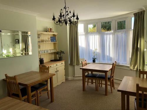 Fernlea Guest house في ويستون سوبر مير: مطبخ مع طاولتين وكراسي وغرفة طعام