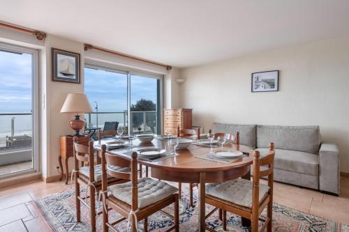 une salle à manger avec une table, des chaises et un canapé dans l'établissement Superbe vue mer à la Baule, à La Baule