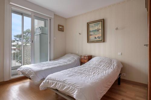 deux lits dans une chambre avec une fenêtre dans l'établissement Superbe vue mer à la Baule, à La Baule