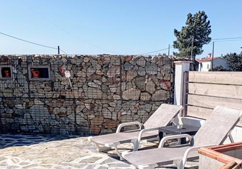 a group of chairs sitting next to a stone wall at Sunset Vista Apartment B in Mação