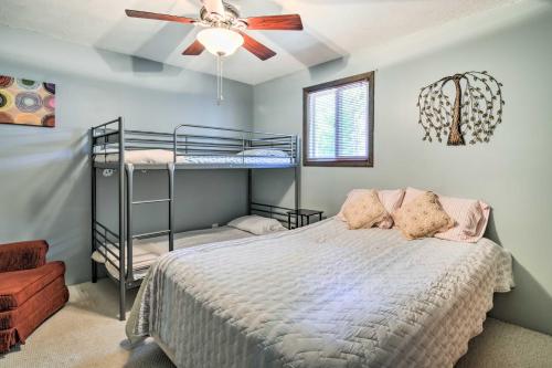 a bedroom with two bunk beds and a ceiling fan at Higgins Lake Getaway with Fire Pit, Walk to Beach! in Roscommon