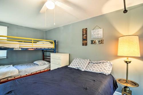 a bedroom with two bunk beds and a lamp at Higgins Lake Getaway with Fire Pit, Walk to Beach! in Roscommon