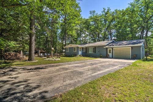 a house with a driveway in front of it at Higgins Lake Getaway with Fire Pit, Walk to Beach! in Roscommon
