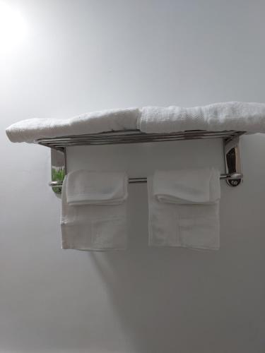 a shelf with white towels on a wall at Apartelle near Philippine Arena in Bulakan