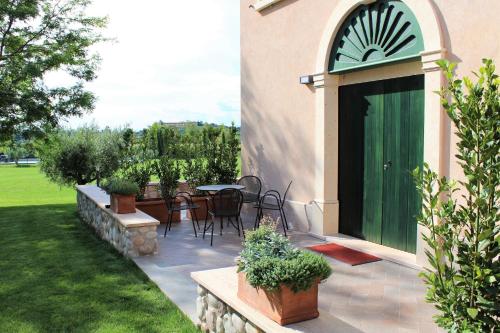 a patio with a table and chairs and a green door at Borgo Romantico Green Relais in Cavaion Veronese