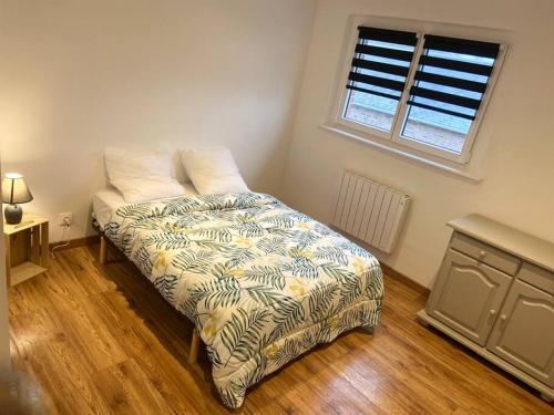 um quarto com uma cama com um edredão e uma janela em Villa du Golf 