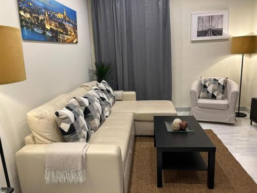 - un salon avec un canapé blanc et une table dans l'établissement Apartamento Fibes-Congresos Parking Gratis, à Séville