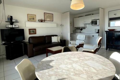 a living room with a table and chairs and a couch at Appartement bord de Mer ・Le rivage・ in Piriac-sur-Mer