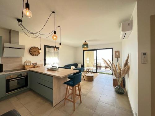 a kitchen and living room with a table and chairs at BEL'ORIZONTE C, 100m des plages et vue mer in Propriano