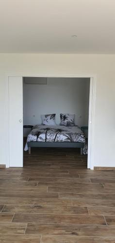 une chambre avec un lit et un parquet dans l'établissement CORSE HOLISTIKA - Rez-de-jardin au calme avec vue mer et piscine magnifique, à Pietrosella