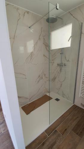 une douche avec une porte vitrée dans une salle de bain dans l'établissement CORSE HOLISTIKA - Rez-de-jardin au calme avec vue mer et piscine magnifique, à Pietrosella