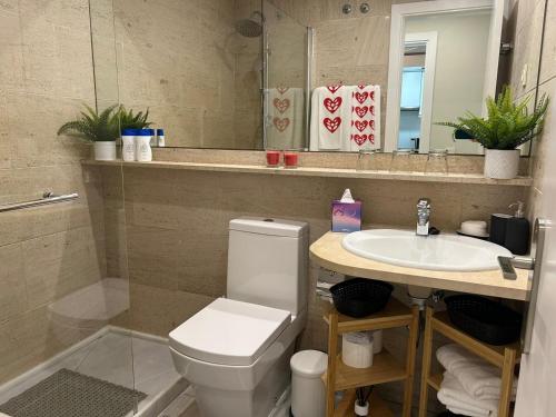 La salle de bains est pourvue de toilettes, d'un lavabo et d'un miroir. dans l'établissement Apartamento Fibes-Congresos Parking Gratis, à Séville