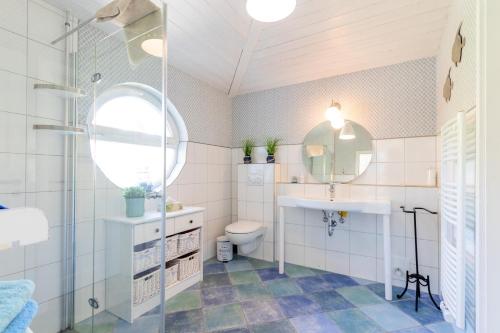 a bathroom with a sink and a toilet and a mirror at Heimathafen 111 in Emden