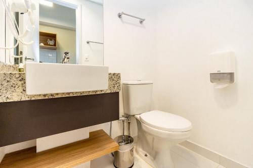 bagno con servizi igienici bianchi e lavandino di Studios Sampa - Brooklin a San Paolo