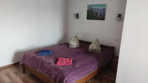 a bedroom with a purple bed with two towels on it at Anastasia in Truskavets