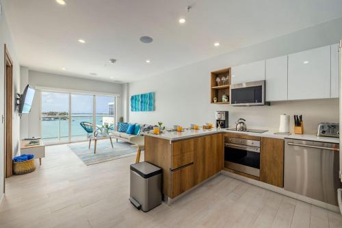 a kitchen with white cabinets and a view of the ocean at HH-2Bdr510 - Luxury Oceanfront Modern apartment in Aruba in Oranjestad