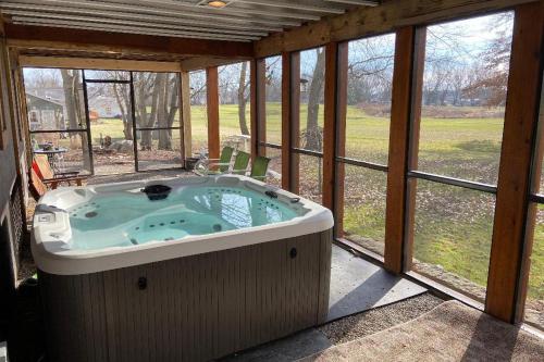 eine Whirlpool-Badewanne auf einer abgeschirmten Veranda in der Unterkunft Updated Buckeye Lake Retreat with Game Room! in Thornville