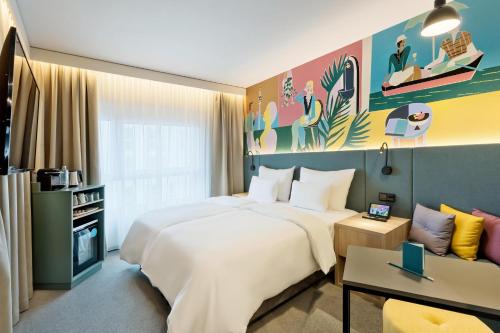 um quarto de hotel com uma cama grande e um sofá em BASSENA Wien Donaustadt em Viena